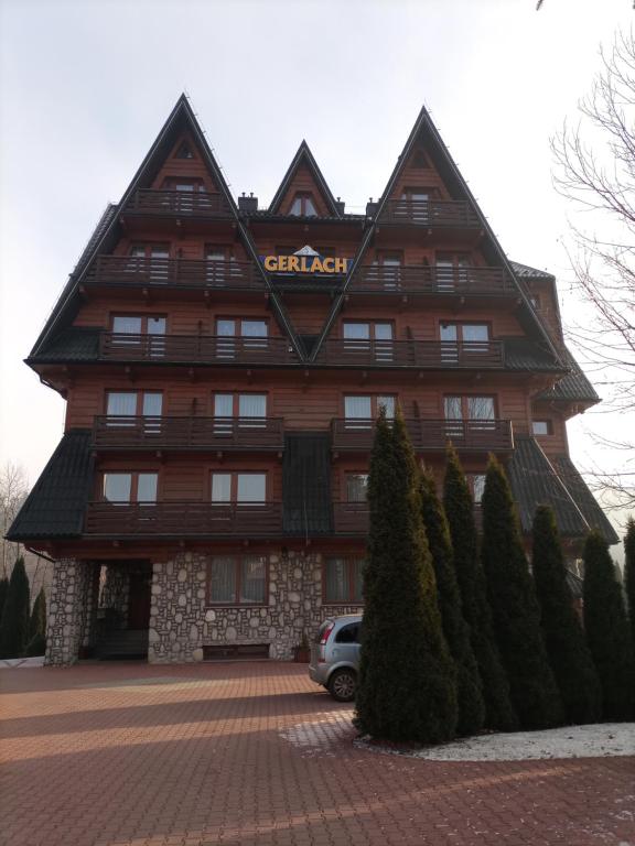 a large wooden building with a sign on it at WynajemPokoi-StołówkaGerlachscŁętowskiWłŁętowskaM ŁętowskaL Łętowska-HyłaB in Białka Tatrzanska