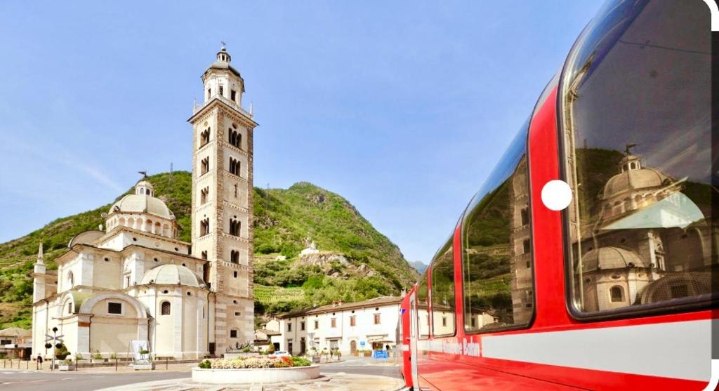 un tren rojo frente a un edificio con una torre de reloj en TIME TO ESCAPE 2, en Tirano