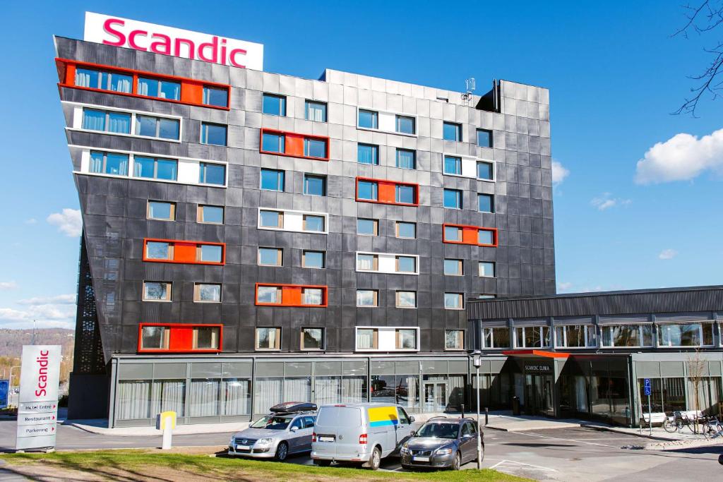 un grande edificio con auto parcheggiate in un parcheggio di Scandic Elmia a Jönköping