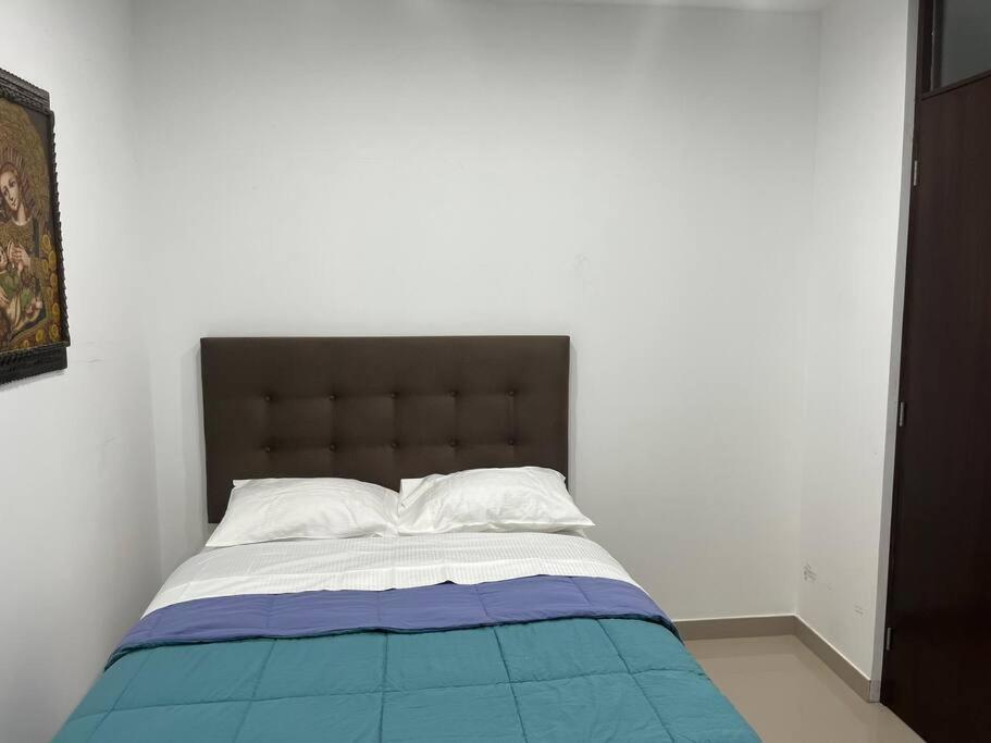 1 dormitorio con 1 cama con manta azul y blanca en MH Apartments Ica 3, en Ica