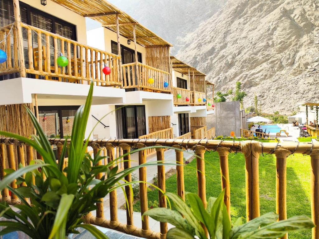 una casa con balcone con una montagna sullo sfondo di Jalara Lunahuaná Hotel a Lunahuaná