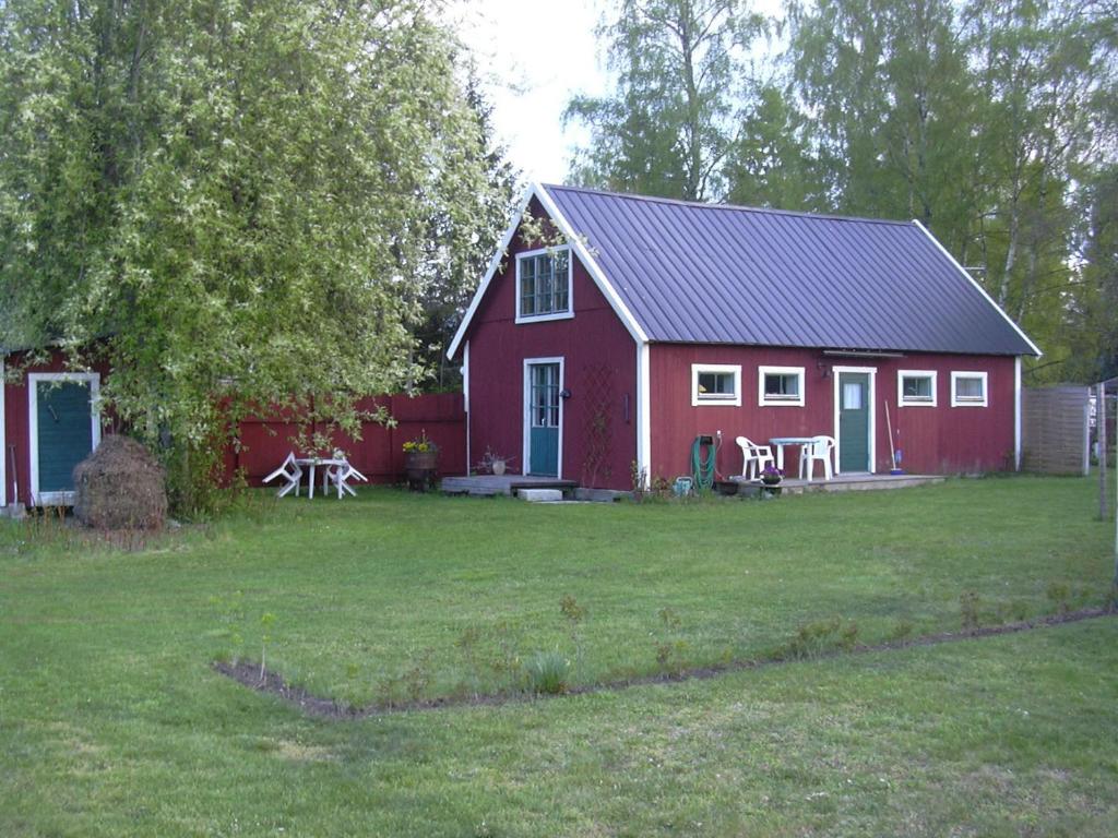 une maison rouge avec une table de pique-nique devant elle dans l'établissement Ringbomsvägen Holiday Home, à Ljugarn