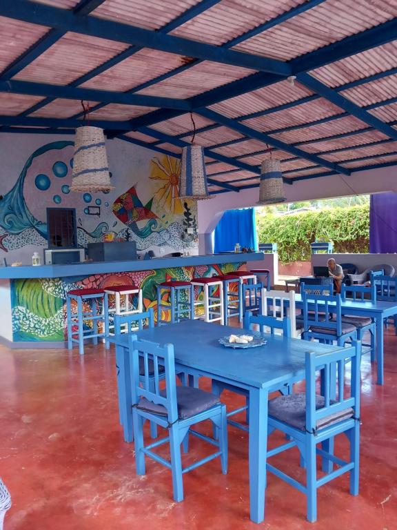 uma sala de jantar com mesas azuis e cadeiras azuis em Il Triangolo Hostel em Las Galeras