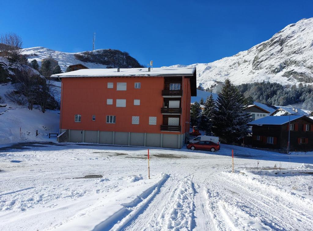 ein Gebäude im Schnee mit einem Auto vor der Tür in der Unterkunft Corn Alv 13 in Bivio