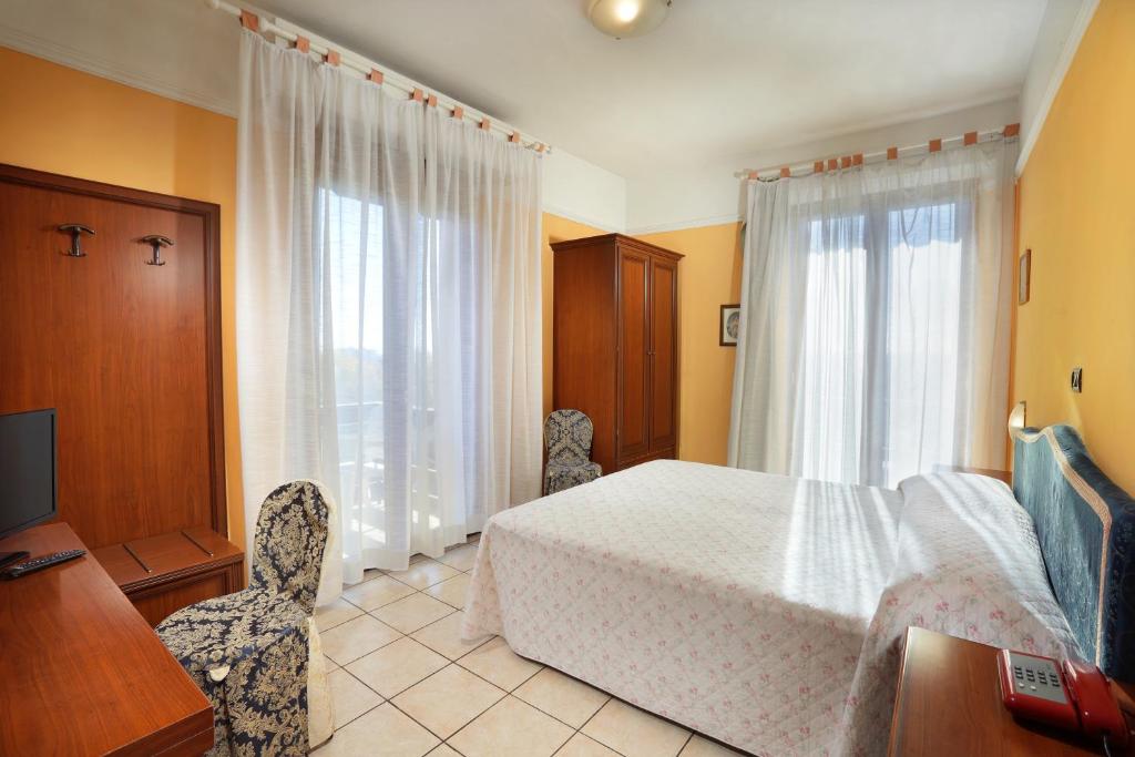 una camera con letto, scrivania e finestra di Hotel Salus a Montecatini Terme