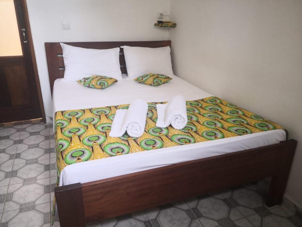 1 cama con 2 toallas y 2 almohadas en Micaval Residential, en São Tomé