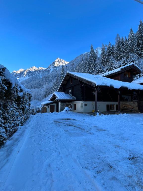 Chalet Galadhrim Chamonix Mont Blanc Valley في لي أوش: طريق مغطى بالثلج أمام مبنى