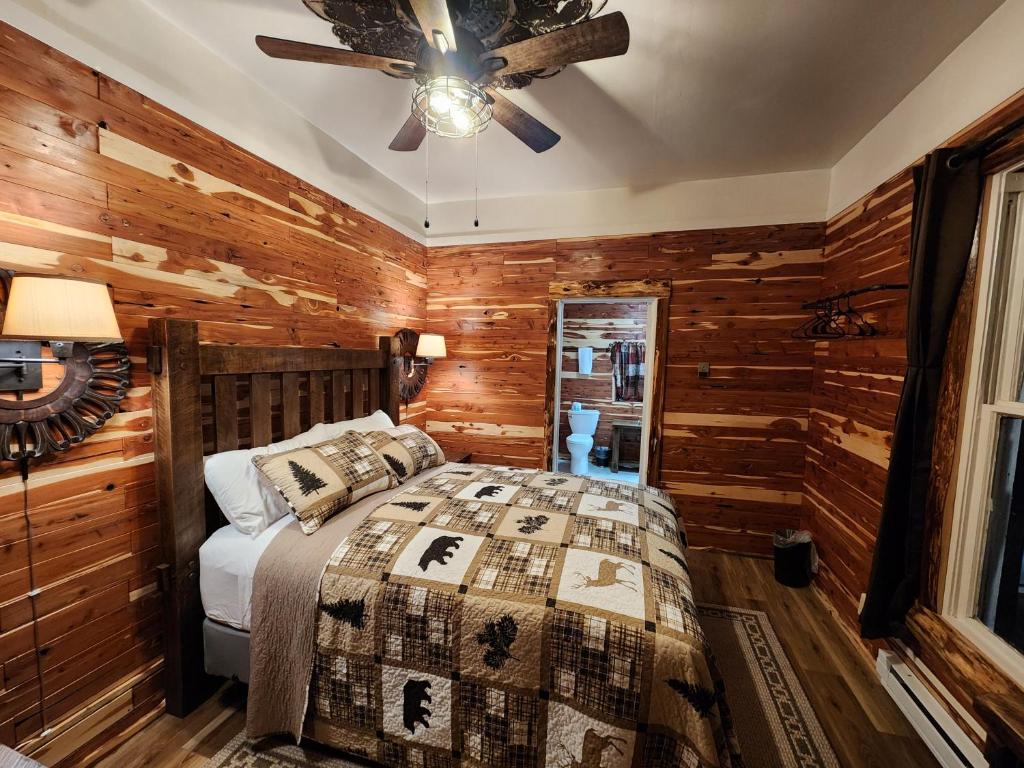 una camera con letto e ventilatore a soffitto di Log Cabin Inn a Eureka Springs