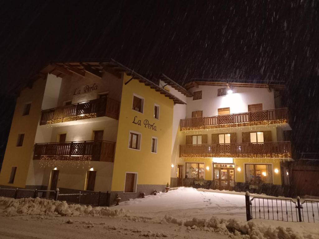 een groot gebouw in de sneeuw 's nachts bij Chalet La Perla Molveno in Molveno