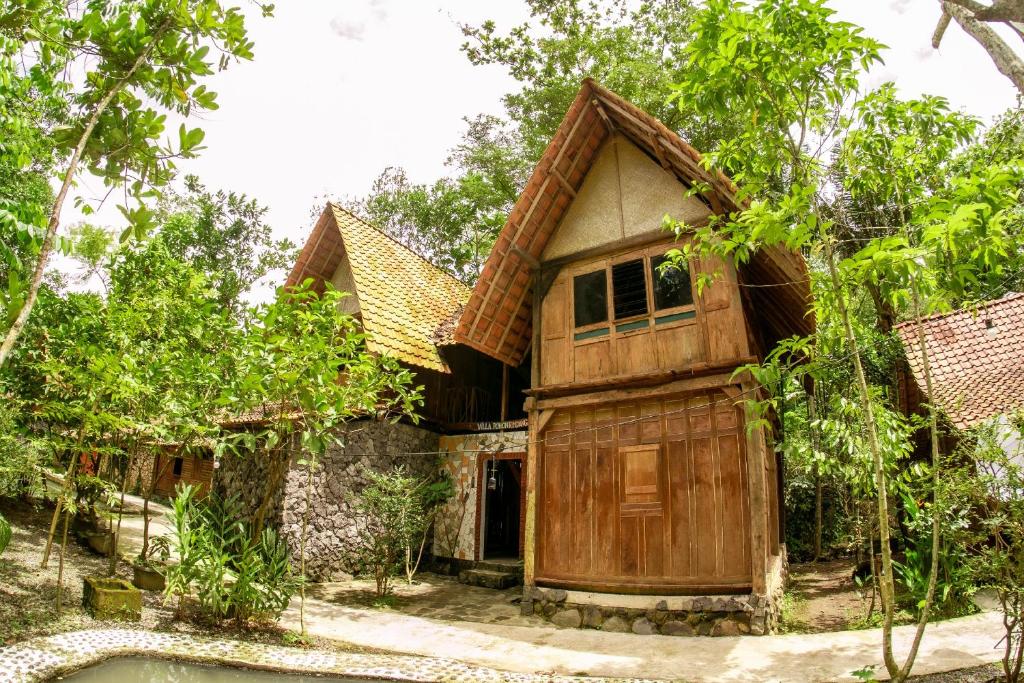 ein Holzhaus mit einem Pool davor in der Unterkunft Villa Kampung Ayem Riverside in Sleman