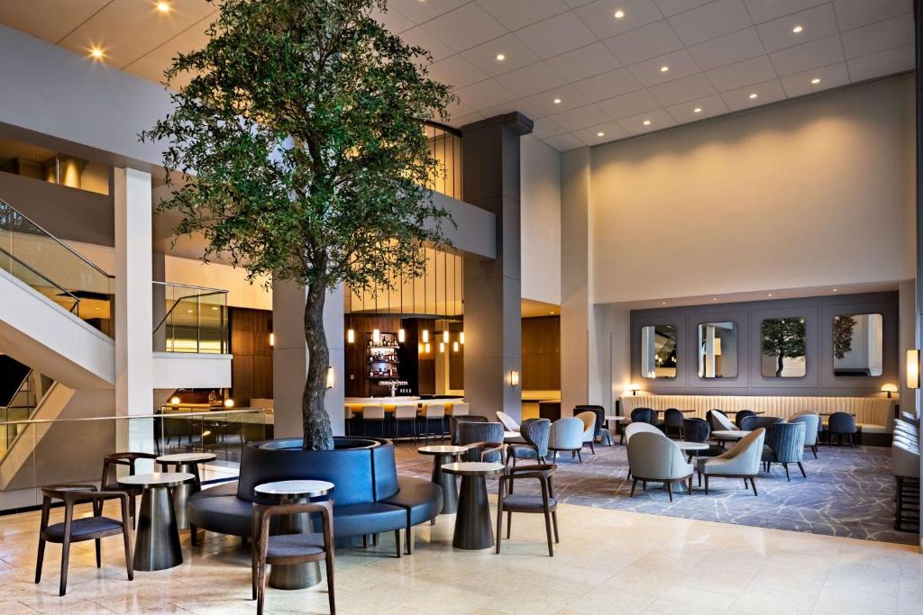 een lobby met tafels en stoelen en een boom bij Hyatt Regency Morristown in Morristown