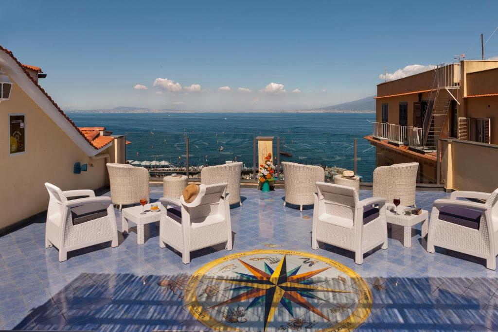 een patio met witte stoelen en uitzicht op de stad bij Hotel Del Mare in Sorrento