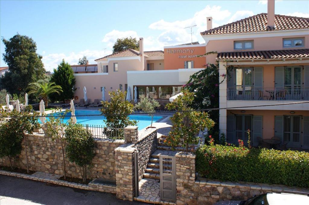 une villa avec une piscine en face d'une maison dans l'établissement Harmony Hotel Apartments, à Selianitika