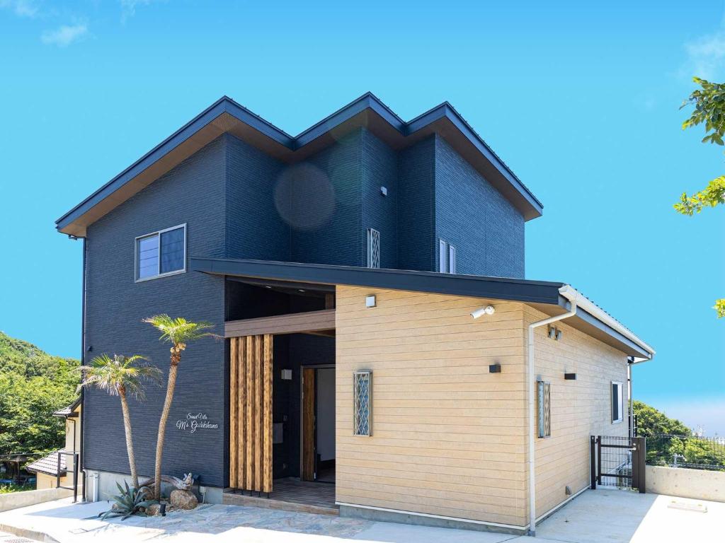 una casa con tetto nero e garage di Sumoto - Cottage - Vacation STAY 24974v a Sumoto