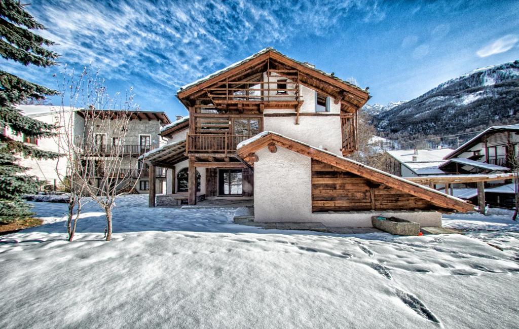 une maison en rondins en hiver avec de la neige dans l'établissement Agriturismo Rivet d'Or, à Pragelato