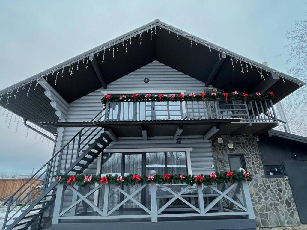 una casa con un balcón con flores rojas. en VIP котедж Рокита, en Mykulychyn