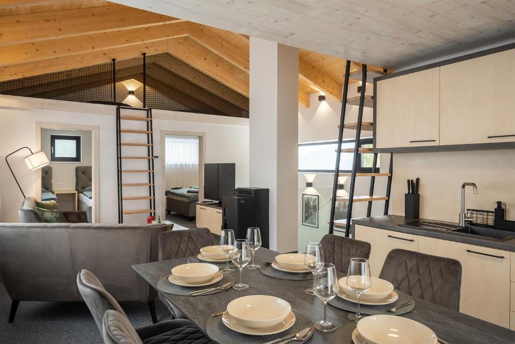 uma sala de jantar com mesa e cadeiras e uma cozinha em Chalet Malino - Apartments em Ružomberok