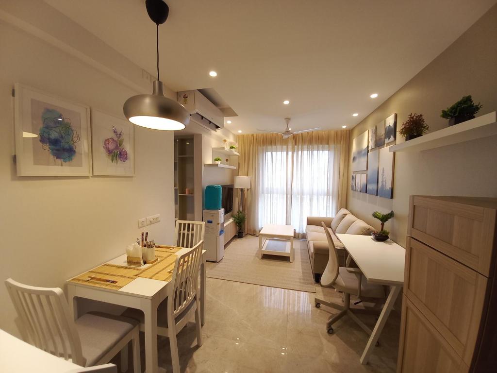 RELOhomes Serviced Apartment في مومباي: مطبخ وغرفة معيشة مع طاولة وكراسي