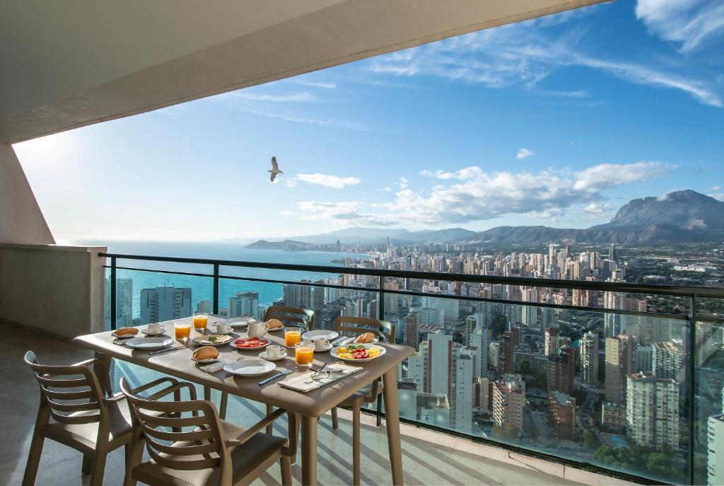 Pierre & Vacances Apartamentos Benidorm Horizon في بنيدورم: طاولة على شرفة مطلة على مدينة