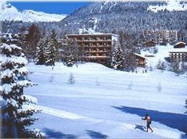 una persona está esquiando en una pista cubierta de nieve en Hotel Belmont, en Crans-Montana