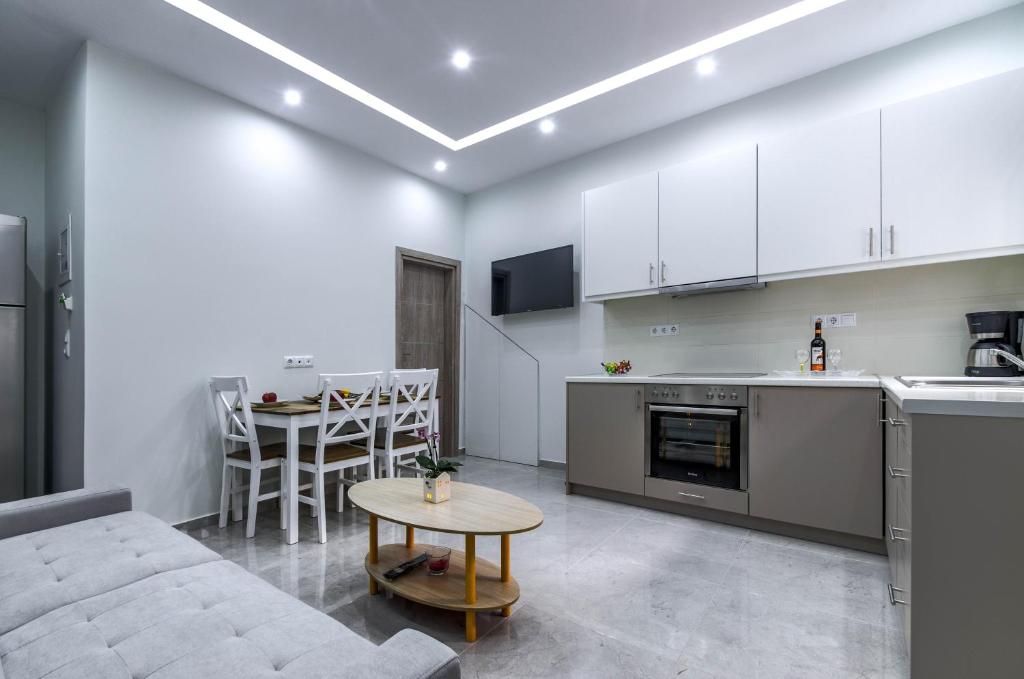 Il dispose d'une cuisine et d'un salon avec un canapé et une table. dans l'établissement Renovated 2BD house close to Pireus port, au Pirée