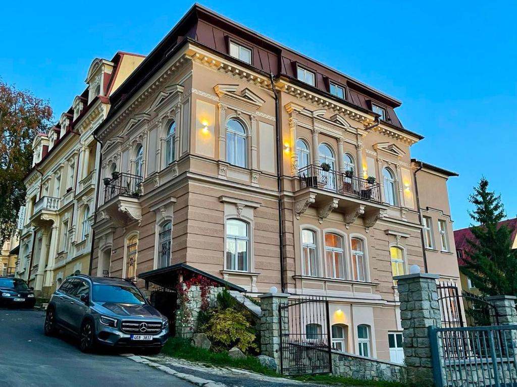 un'auto parcheggiata di fronte a un grande edificio di Apartment Villa Frank a Mariánské Lázně