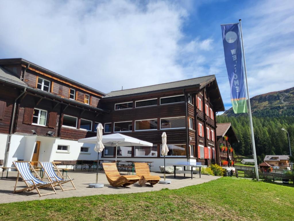 un edificio con sedie e una bandiera di fronte ad esso di Ferienhaus Davos "Ob dem See" a Davos