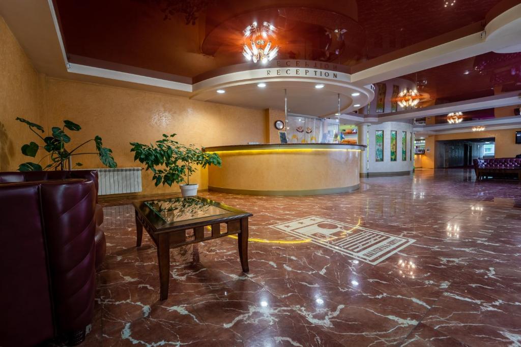 a lobby with a table in the middle of a room at Hotel Halychyna in Ternopilʼ