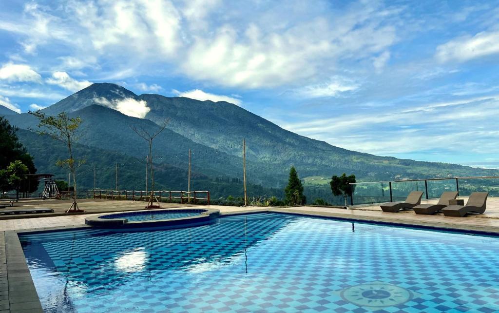 une piscine avec une montagne en arrière-plan dans l'établissement Alinson Sunset Hill, à Bogor