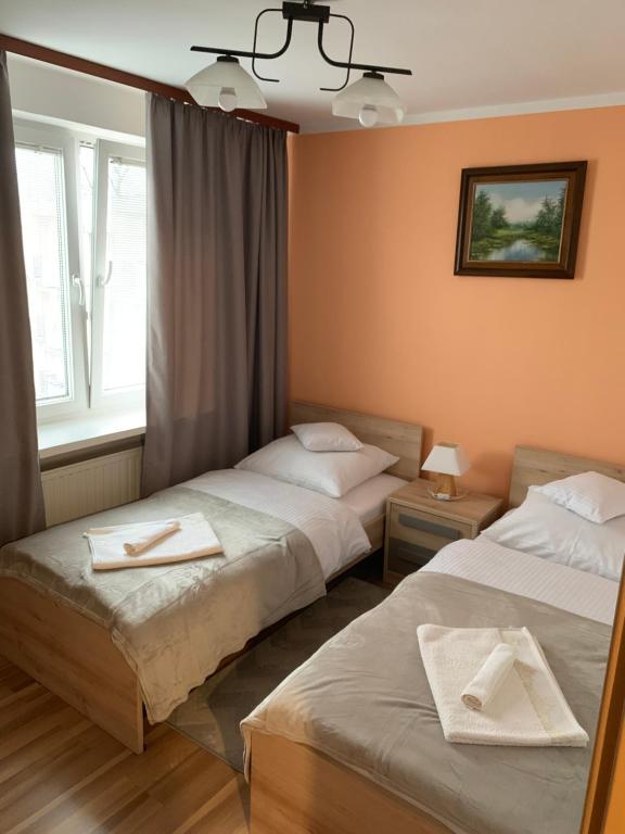 Habitación de hotel con 2 camas y ventana en Apartament Praski 5 minut od metra i starego miasta spacerem do zoo i Konesera, en Varsovia