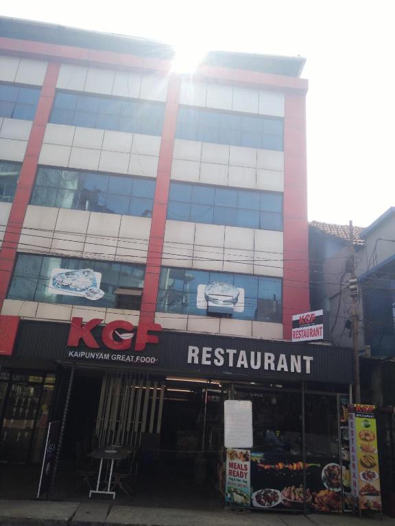 um edifício com uma placa de restaurante kfc em frente em Taj Rest' inn em Kannur