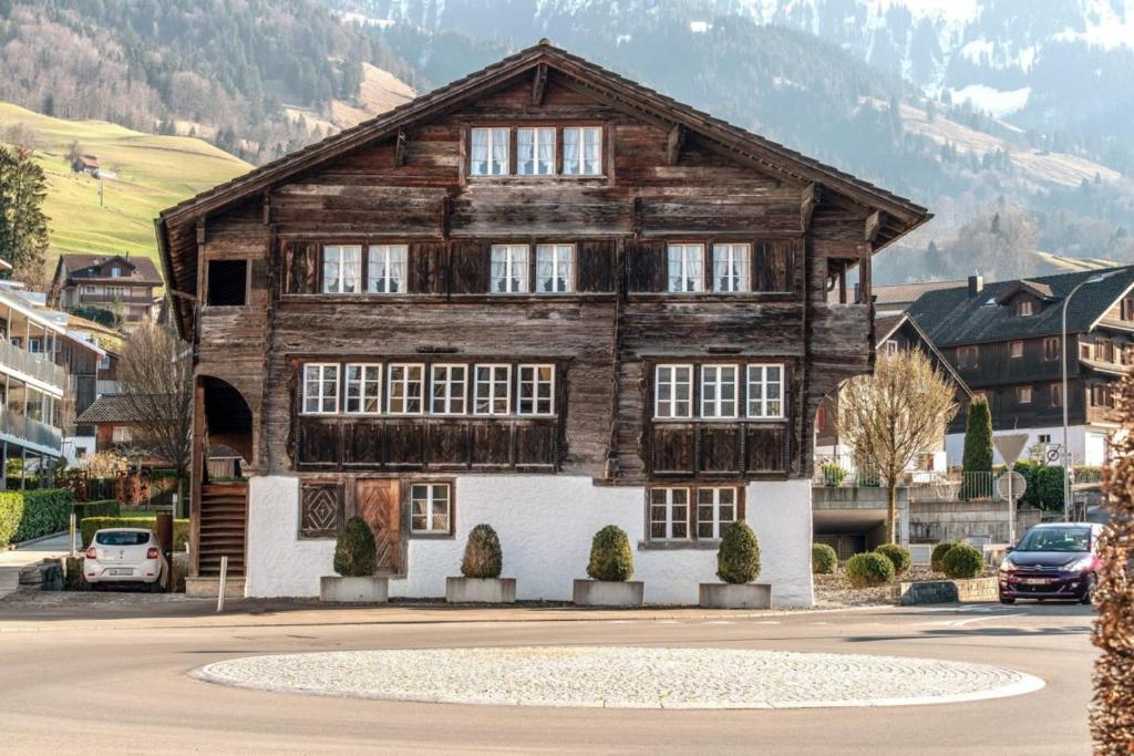 a large wooden house with windows on a street at Farbhaus by Kreuz Sachseln in Sachseln