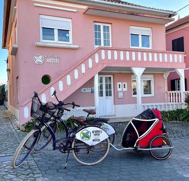 een fiets geparkeerd voor een roze huis bij Granny´s Guesthouse in Praia de Mira