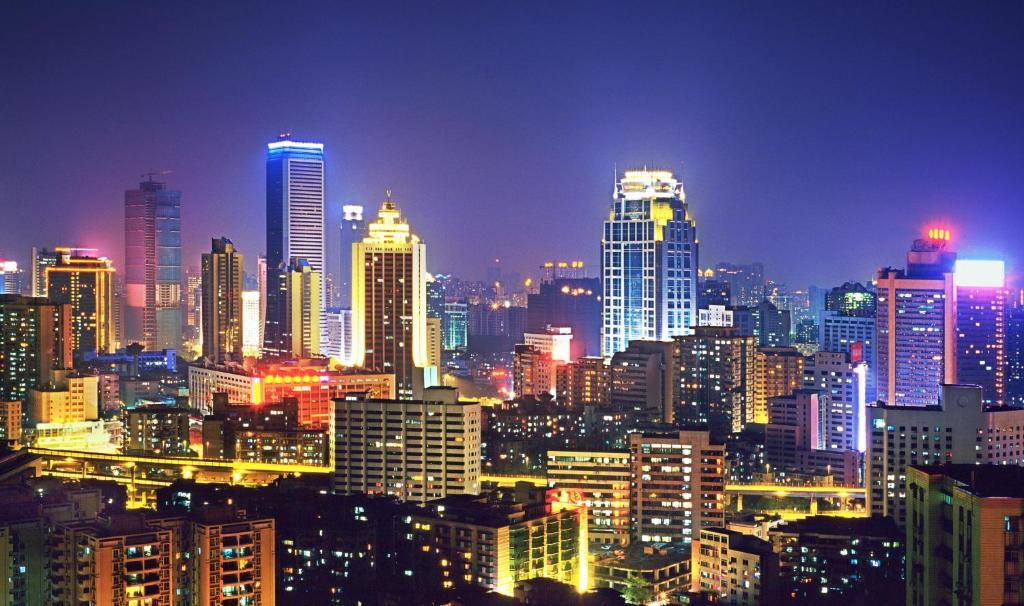 um horizonte da cidade à noite com edifícios iluminados em Asia International Hotel Guangdong em Guangzhou