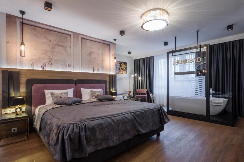 sypialnia z dużym łóżkiem i wanną w obiekcie Design Hotel Winterrot w mieście Karlsruhe