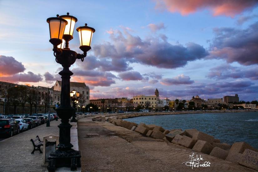 uma luz de rua num passeio ao lado de uma massa de água em Hotel de Rossi em Bari