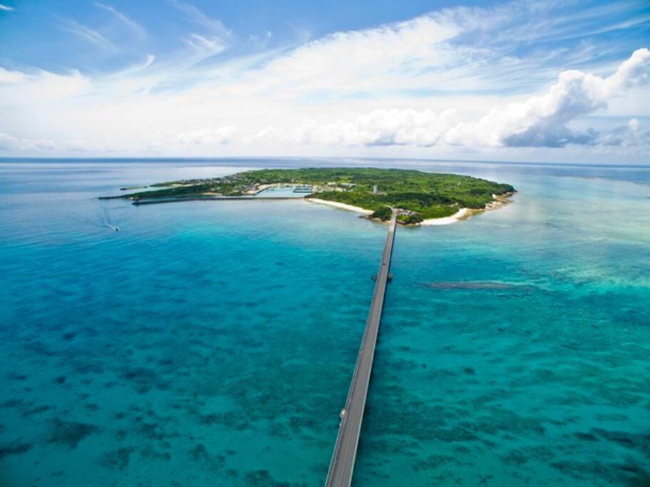 eine Insel im Ozean mit einer Brücke darüber in der Unterkunft 「池間島の一棟貸切りの宿アロハナ」日本最大級のサンゴ礁群ヤビジに最も近い宿。夕陽,海まで徒歩3分 in Miyako-jima