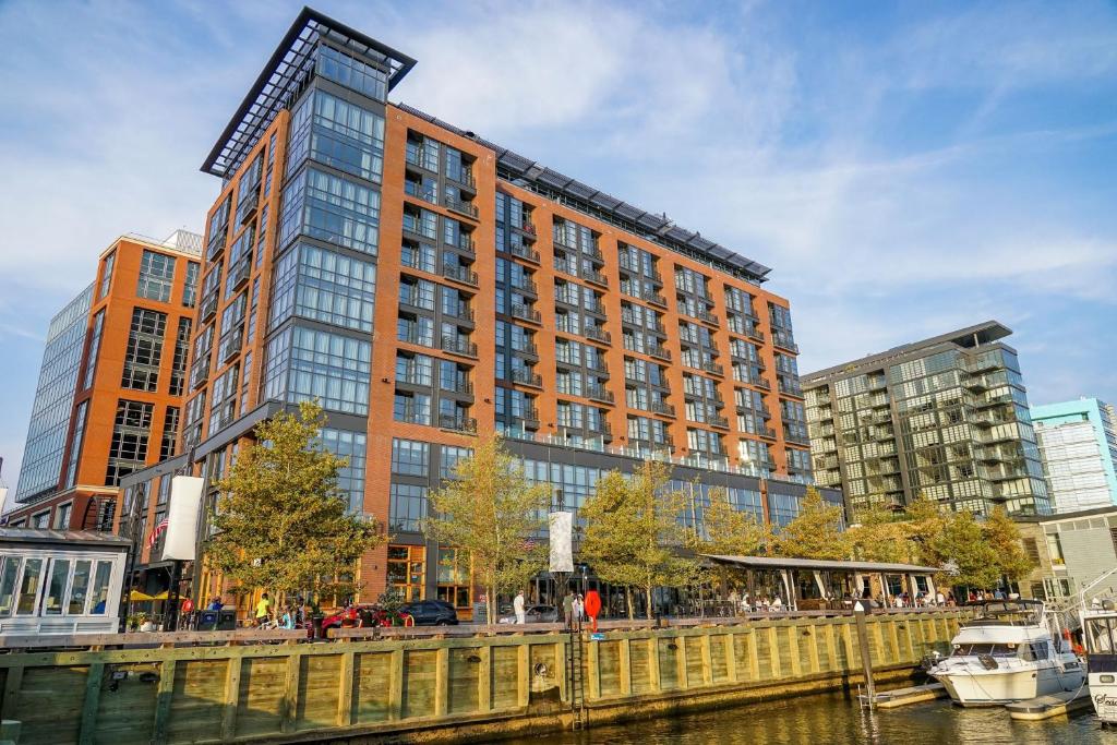 a tall building next to a river with a boat at InterContinental - Washington D.C. - The Wharf, an IHG Hotel in Washington