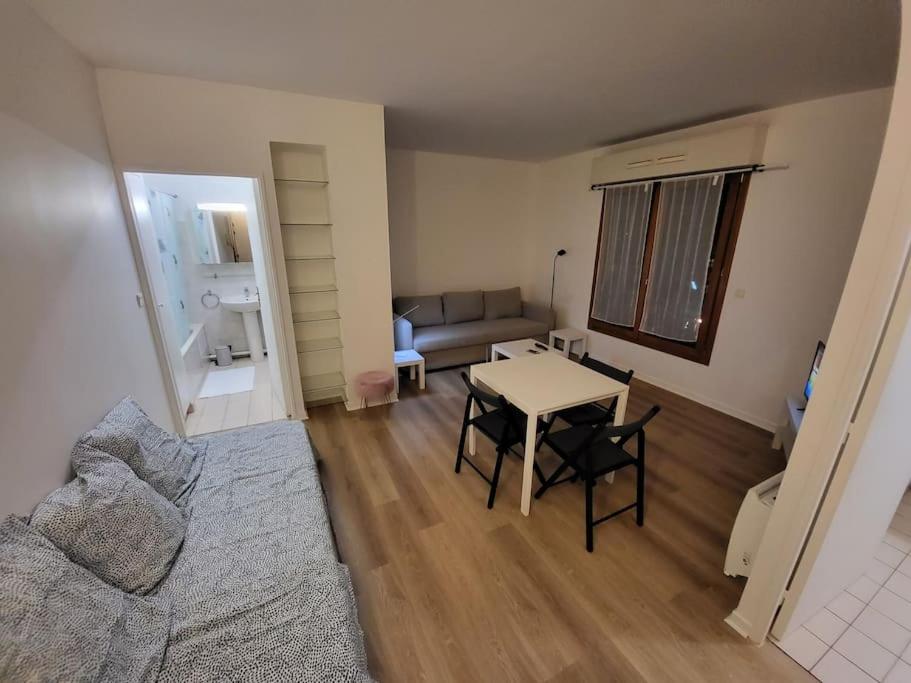 a living room with a table and a couch at Charmant studio Porte St Cloud in Boulogne-Billancourt