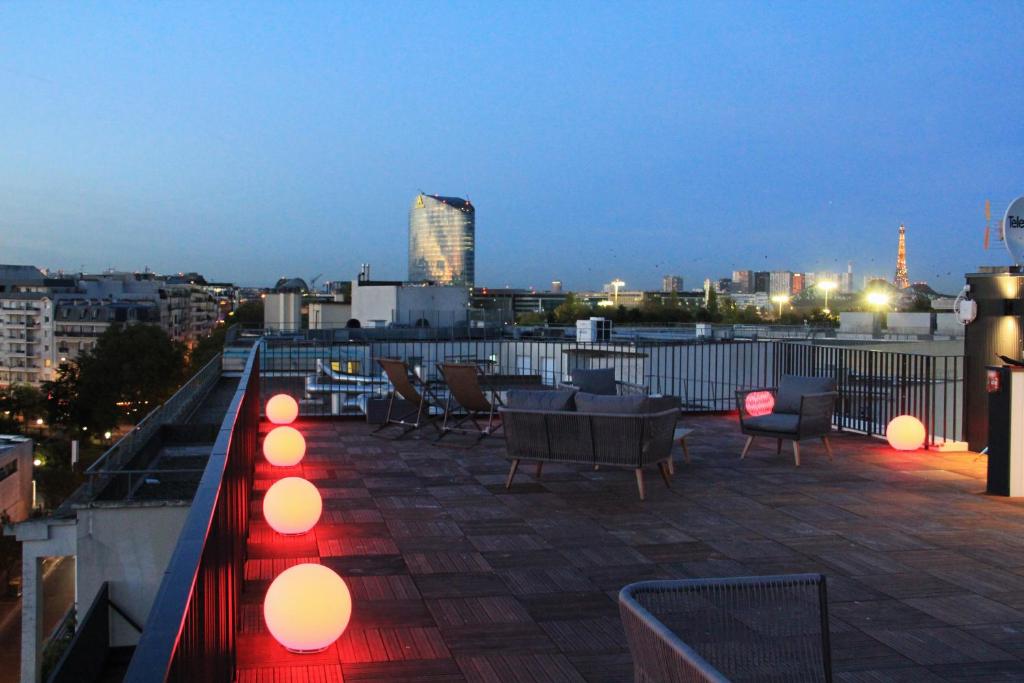 un patio all'ultimo piano con sedie e luci su un edificio di FINESTATE Coliving Mairie d'Issy a Issy-les-Moulineaux