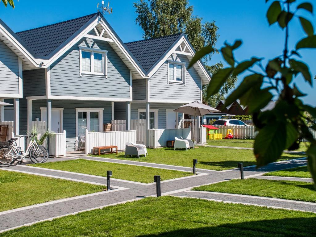 een grijs huis met een tuin met een huis bij Holiday Bay in Władysławowo