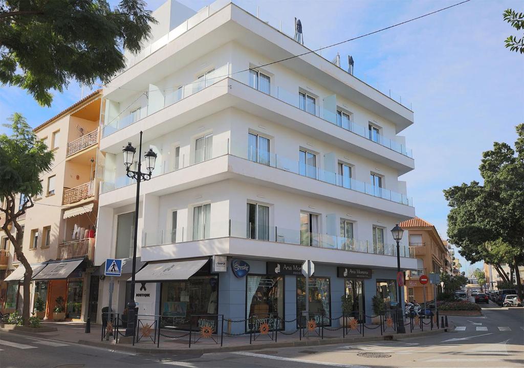 een hoog wit gebouw op de hoek van een straat bij Terrace Costa Hotel in Fuengirola