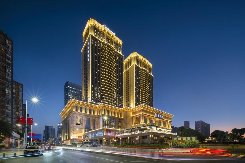 un grand bâtiment dans une ville la nuit dans l'établissement Oakwood Residence Foshan, à Foshan