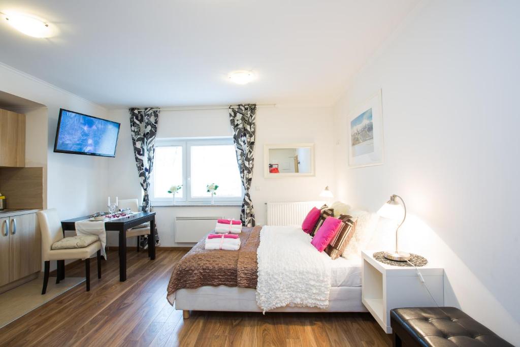 a bedroom with a bed and a desk and a window at Bled Apartments in Bled