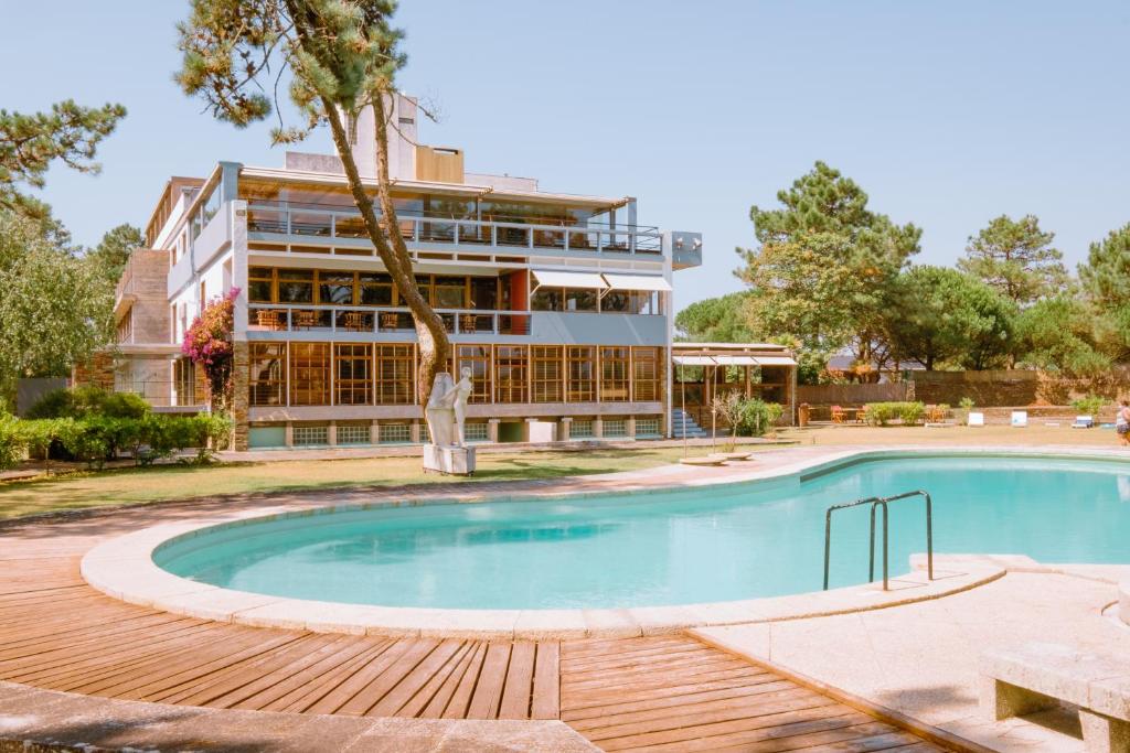 a hotel with a swimming pool in front of a building at Parque do Rio Ofir Hotel in Esposende