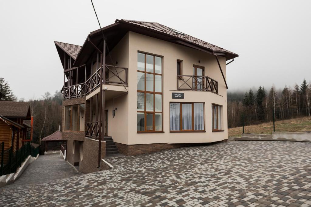 uma casa com uma varanda numa entrada de pedra em Гірська феєрія em Myhove