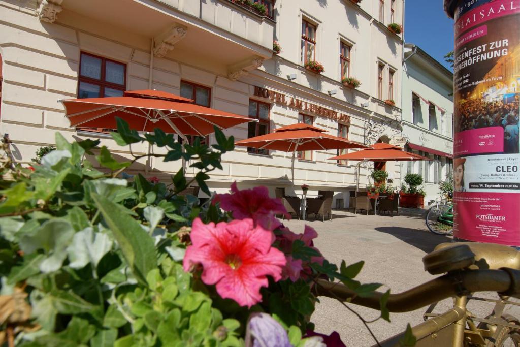 een bos bloemen voor een gebouw met paraplu's bij Hotel am Luisenplatz in Potsdam