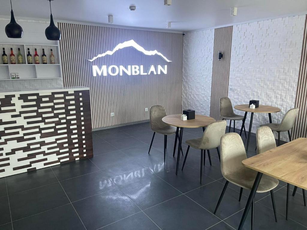 un restaurante con mesas y sillas y un cartel en la pared en Отель MONBLAN, en Yablunytsya