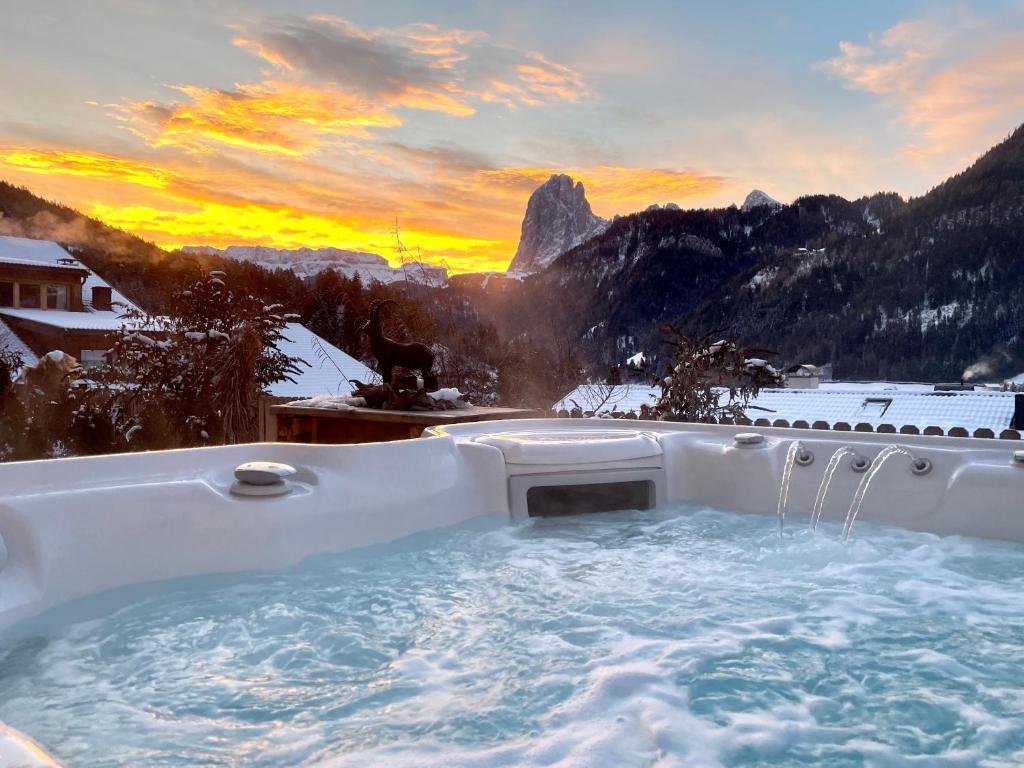 een hot tub met uitzicht op de bergen bij Chalet Bernardi Apartments in Ortisei