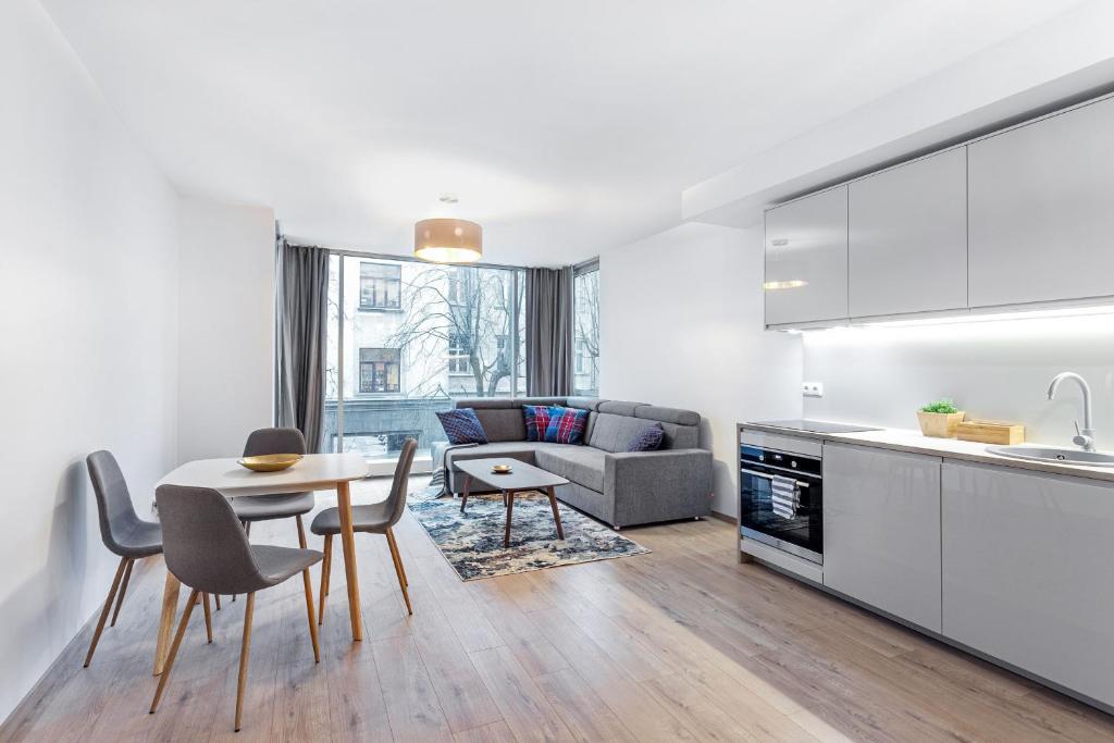 a kitchen and living room with a table and chairs at Business Apartment In Jaksto Street in Vilnius